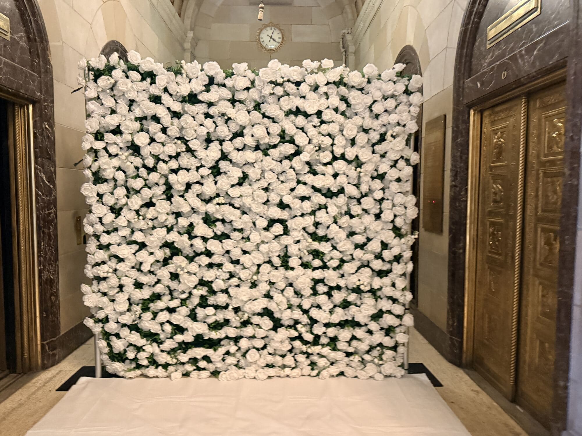 Mur de roses blanches dressé devant les portes de bronze de l'ancienne salle bancaire, Montréal